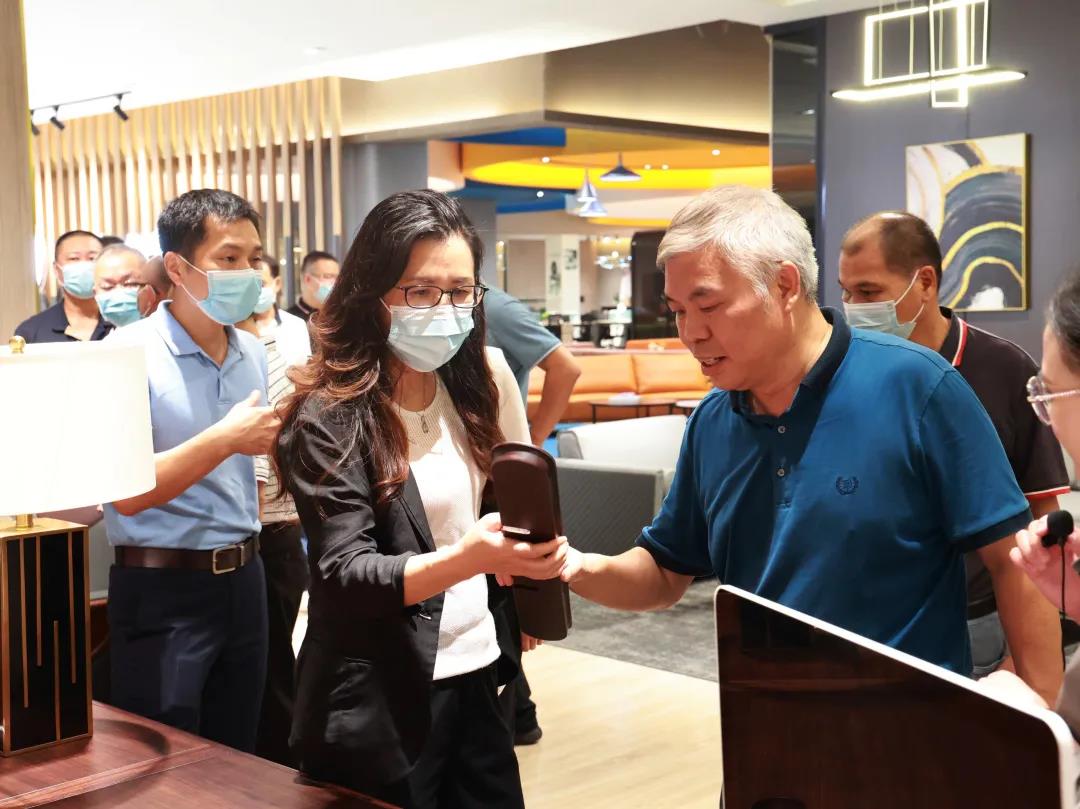 妖精网站免费观看家具集團董事副總裁黃雲林為調研組展示實木辦公家具產品